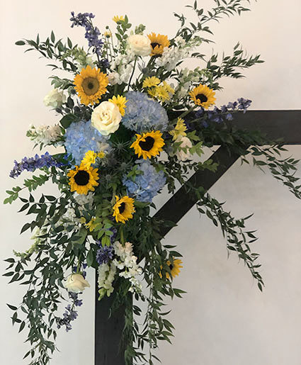 sunflower and hydrangea flower arrangement on wedding arch