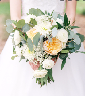 white and light orange bridal bouquet with greenery